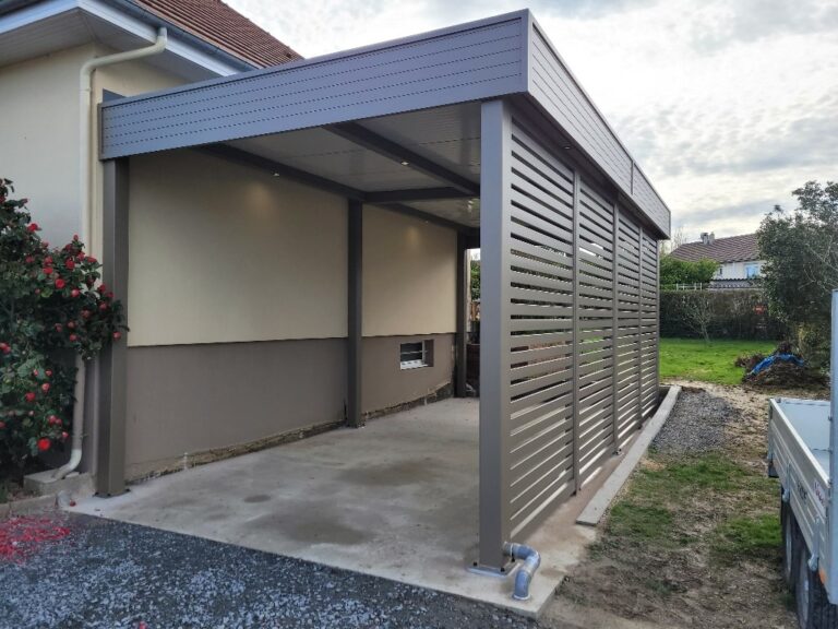 Abri de voiture moderne en métal près d'une maison.
