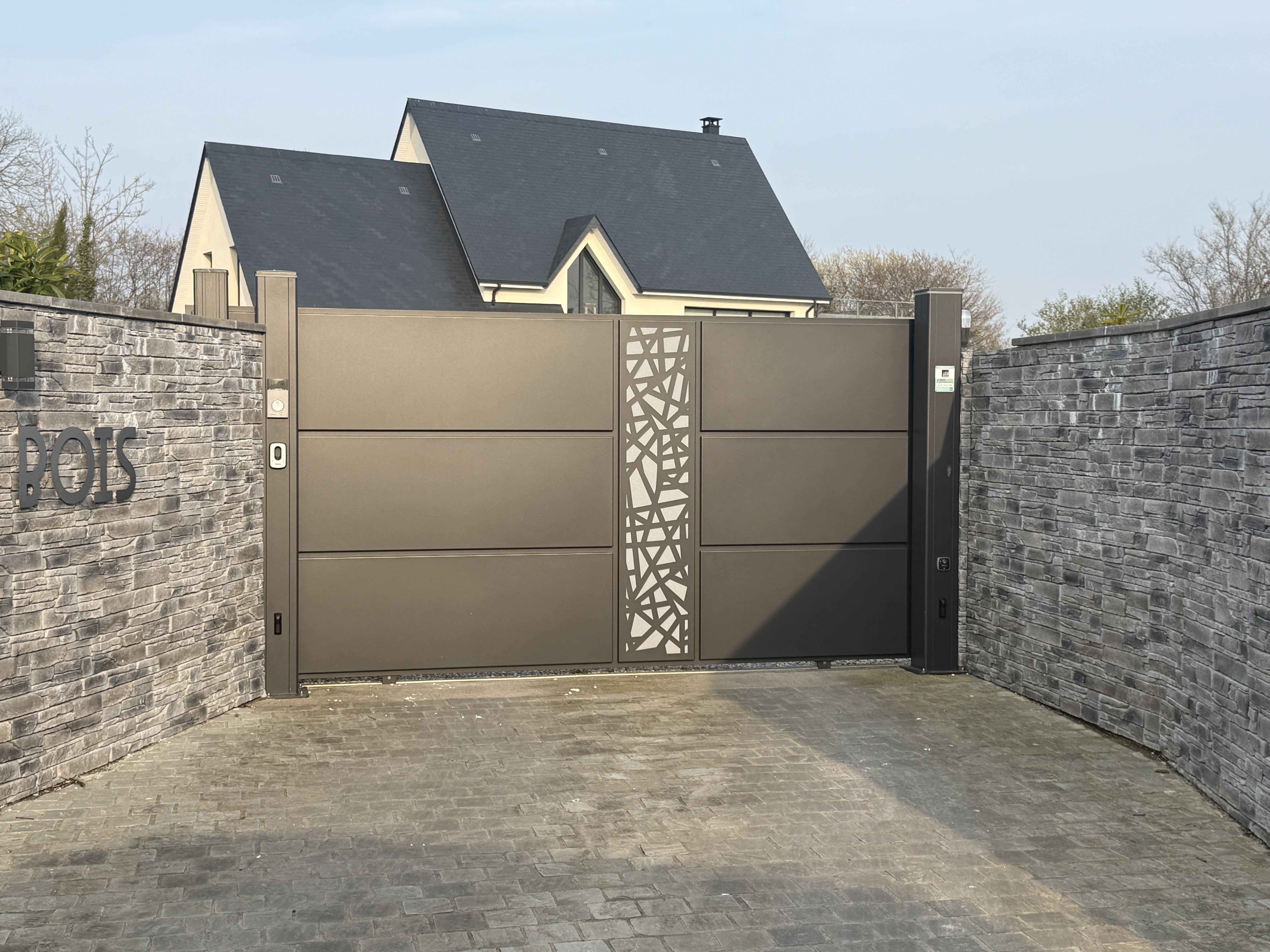 Portail moderne en métal devant une maison.