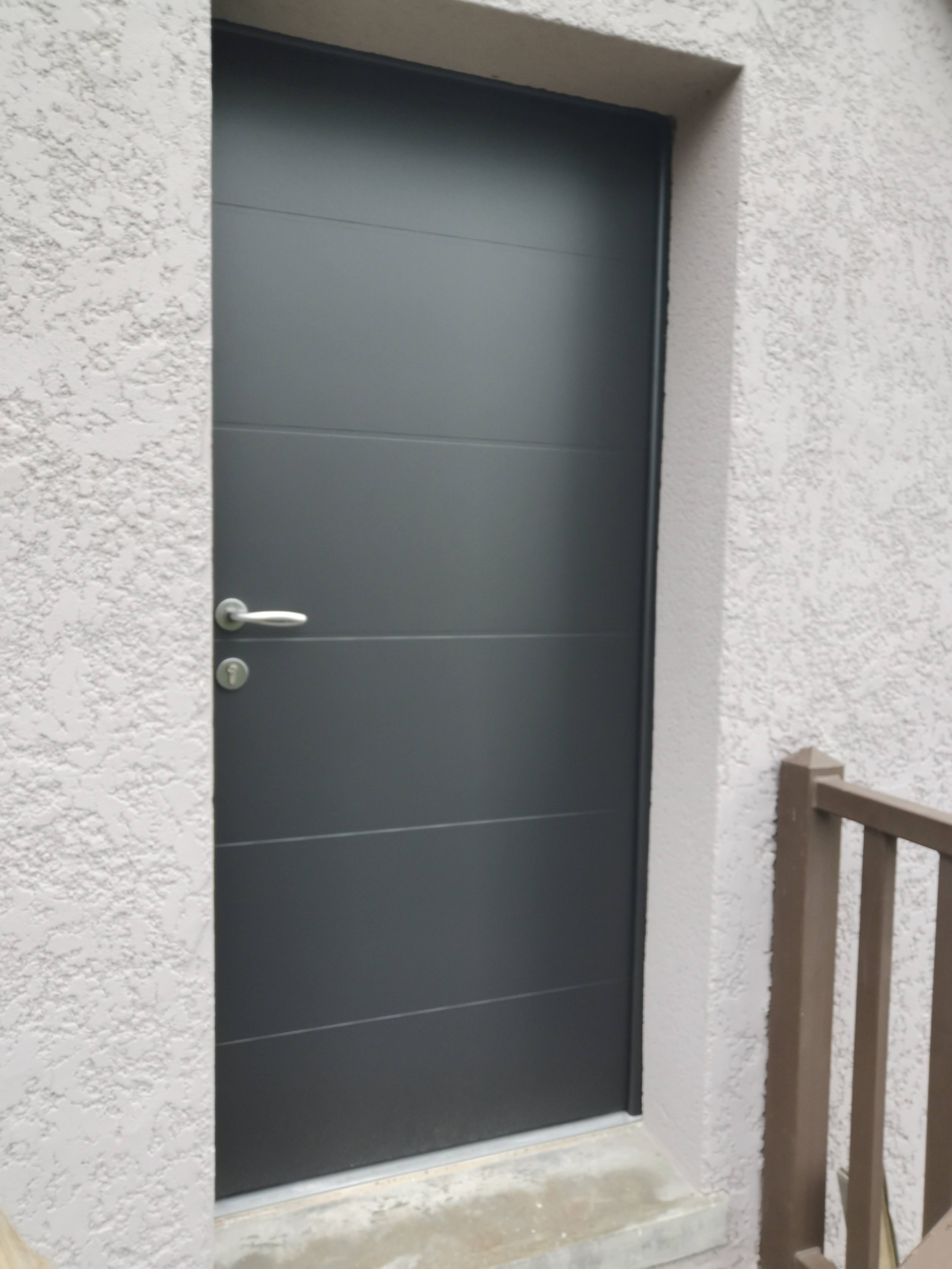 Porte grise moderne sur mur texturé.